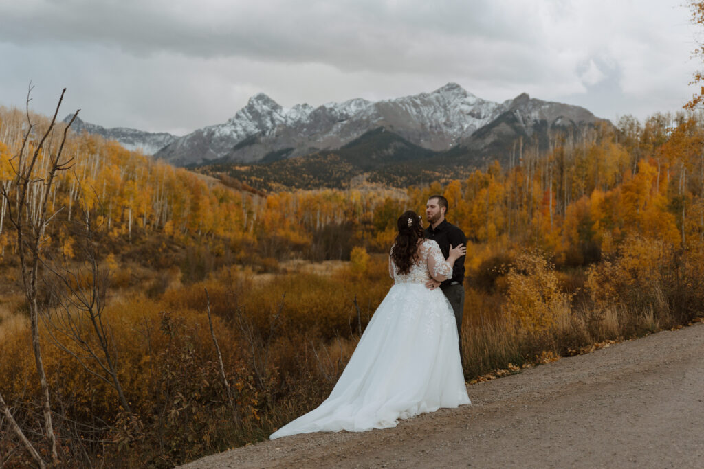 Golden aspens in fall framing a couple during their Telluride elopement ceremony.