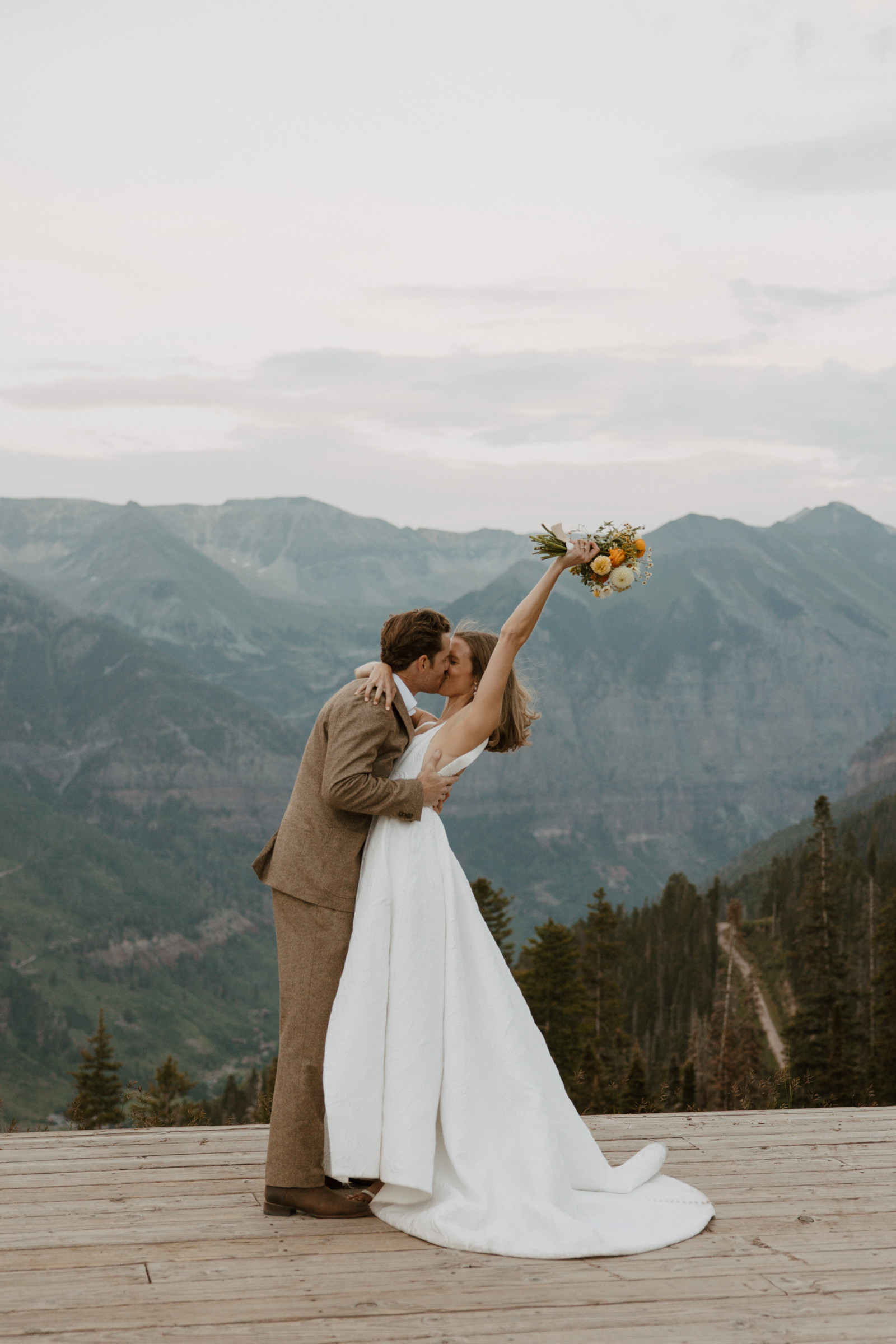 Image of a couple exchanging vows at San Sophia Overlook in Telluride, Colorado, with mountain peaks in the background.